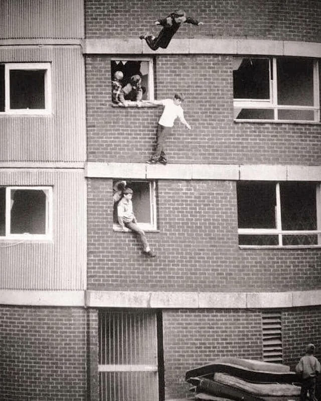 Kinder hüpfen auf abgenutzten Matratzen. England, 1980er Jahre.