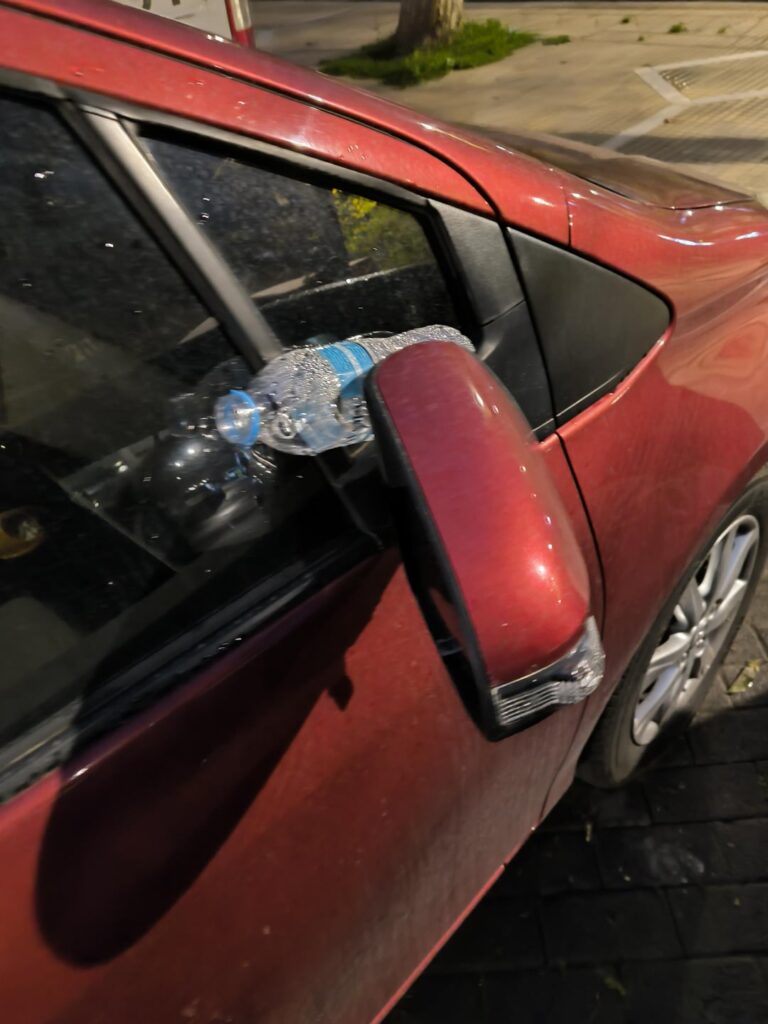 Keilflasche Wasser im Autospiegel. Ist es eine Nachricht von erhöhten Scheibenwischern?