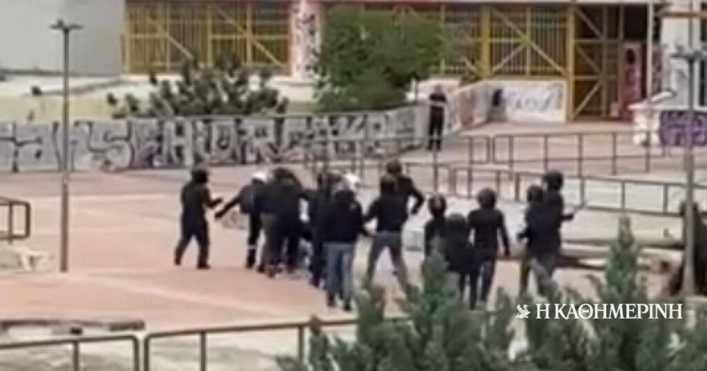 Ungefähr 15 Menschen mit Helmen unterscheiden sich, einen Mann am Boden zu haben und ihn mit Strahlen und Tritten zu schlagen. Ungefähr 15 Menschen mit Helmen unterscheiden sich, einen Mann am Boden zu haben und ihn mit Strahlen und Tritten zu schlagen.