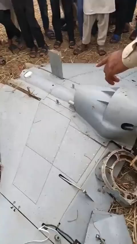 Pakistanische Einheimische diskutieren, um die Ersatzteile von Downed Drohne für seinen kaputten Kühlschrank zu verwenden (sieht aus wie ein Harop)