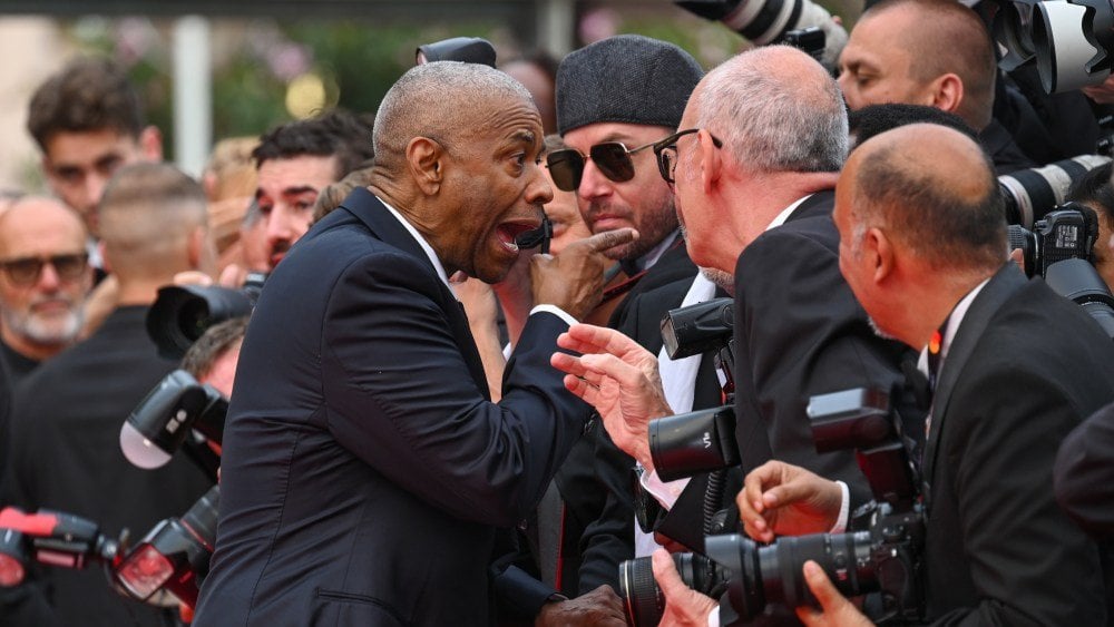 Denzel Washington scheint sich gegen aufdringliche Fotograf von Cannes zu wehren und schreibt 'Stop!' Während des angespannten Moment des roten Teppichs