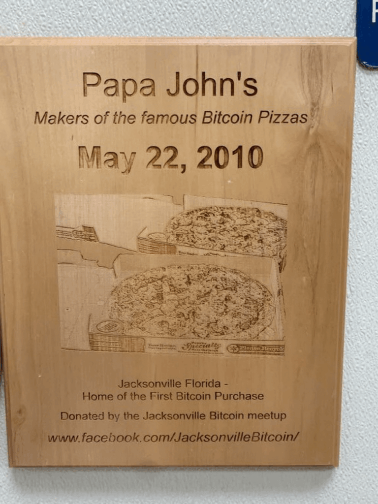 Diese Plakette hängt an der Wand bei Papa Johns in Jacksonville, Florida, um den ersten Kauf von Bitcoin Pizza zu erinnern