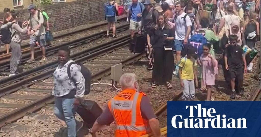 Evakuierte Londoner Zugpassagiere, die gezwungen sind, am heißesten Tag des Jahres entlang der Gleise zu gehen Evakuierte Londoner Zugpassagiere, die gezwungen sind, am heißesten Tag des Jahres entlang der Gleise zu gehen