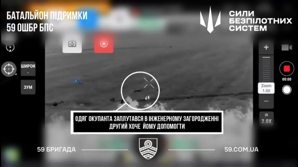 Eine ukrainische Drohne entdeckt, dass ein russischer Soldat, der einem anderen russischen Soldaten helfen möchte, aus Barbohr herauszukommen und eine Munition auf sie fallen zu lassen.