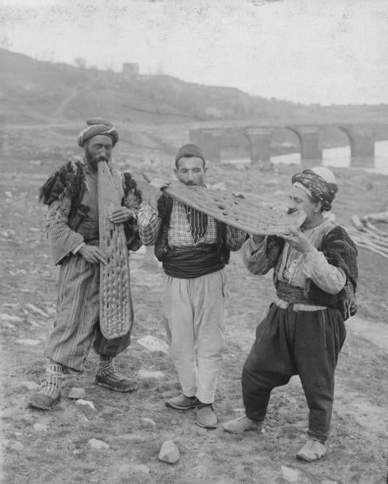 Zehn -go Kopru in Diyarbakir 3 Freunde, die bei einer Übertreibung tolles Brot essen. Das Datum des Fotos ist ungewiss.