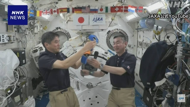 Zwei japanische Astronauten veranstalten eine Pressekonferenz von ISS