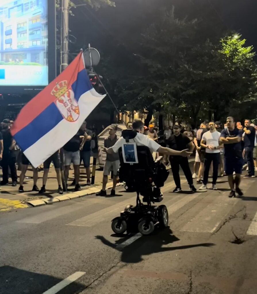Mann im Rollstuhlfahrten gegen Vucics Schläger (Quelle: N1 Serbien)