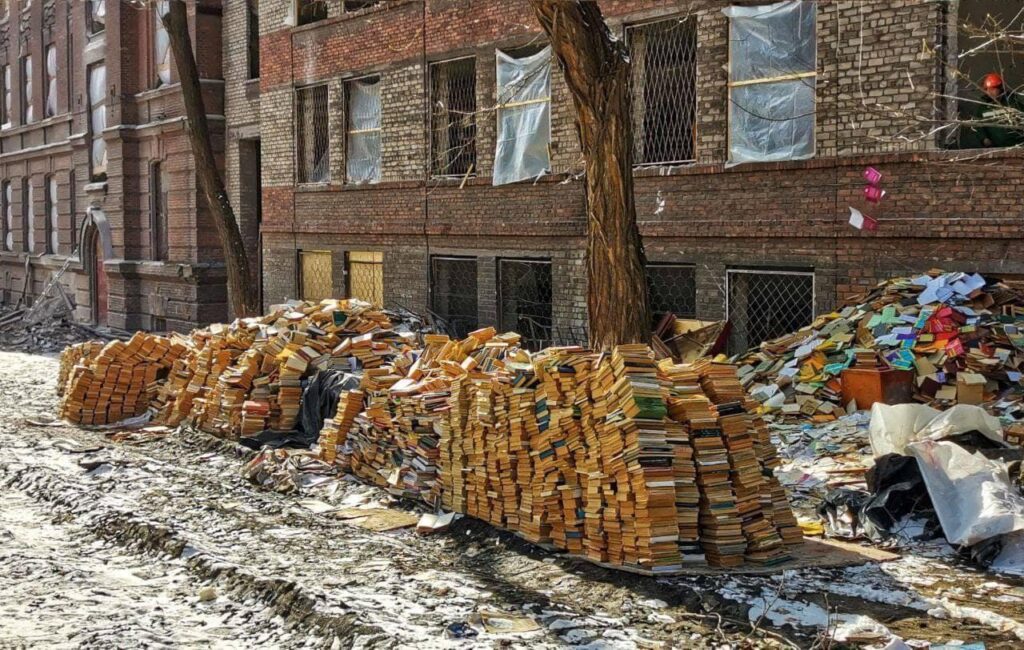 Russische Besatzer werfen Bücher in Ukrainisch aus der Bibliothek der Pryazovsk University in Mariupol weg und bereiteten sie auf die Zerstörung vor. Quelle ist Mariupol Stadtrat