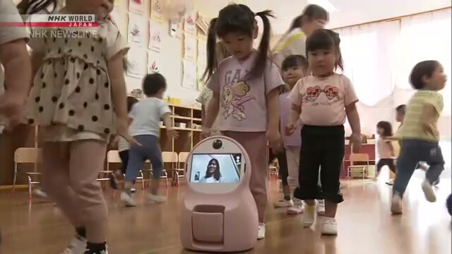 Kindergärten spielen mit Roboter, während es ihre Entwicklung misst