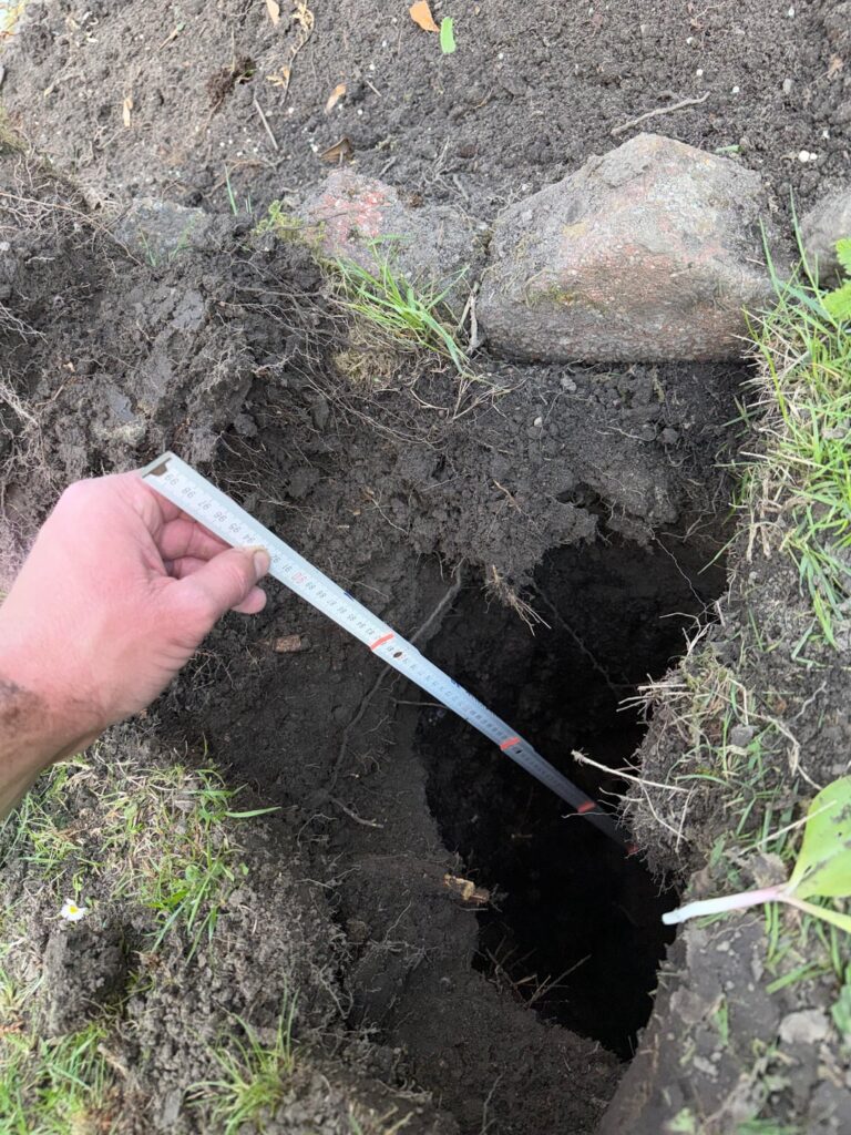 Seltsames Loch unter meinem Rasen. 1 Meter tief, 20 cm breit inkl. verrottetes Holz in der Mitte?