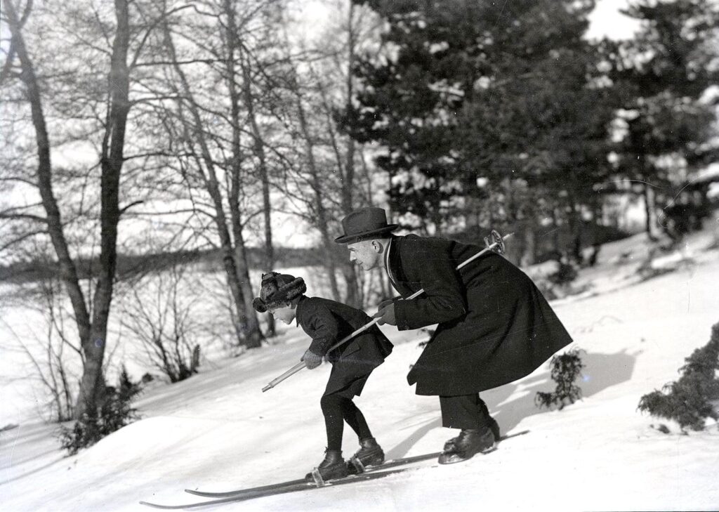 „Vater bringt seinem Sohn das Skifahren bei“. Foto: Abel Fritiof Eriksson (1891 – 1950; ein finnischer Fotograf). Finnland (Finnland) - Uusikaupunki, 1925 [1477x1052]