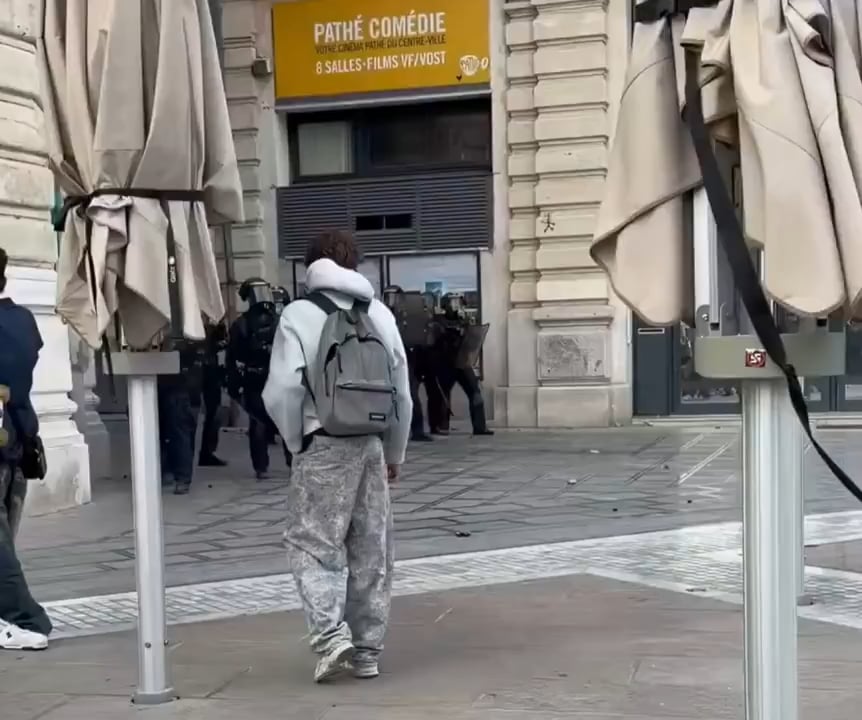 Ein Polizist, der mit einer Blendgranate auf den Kopf eines Gymnasiasten zielt. (6. Oktober 2026. Place de la Comédie in Montpellier)