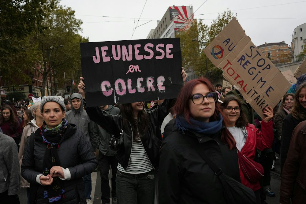 Demonstrierende tragen in Paris ein Schild mit der Aufschrift „Wütende Jugend“.